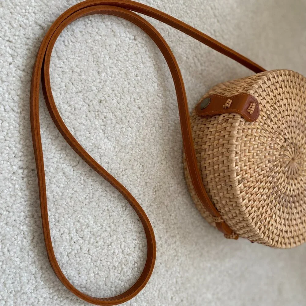 Round solid rattan woven crossbody purse cloth lined, leather accents.